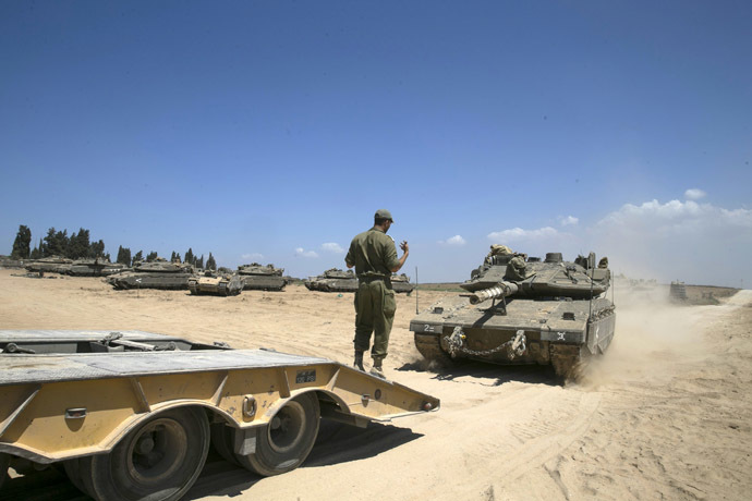 An Israeli soldier directs a tank onto a truck at a staging area near the border with the Gaza Strip August 27, 2014. (Reuters)