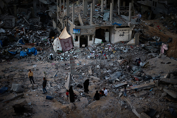 Palestinians sit atop the ruins of their house which witnesses said was destroyed during the Israeli offensive, in the east of Gaza City September 3, 2014 (Reuters / Suhaib Salem)