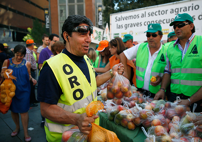 People take fruits and vegetables given away in central Madrid by Spanish farmers to protest against Russia's ban on vegetables, meat, fish, milk and dairy imports from the European Union, September 5, 2014 (Reuters / Andrea Comas)