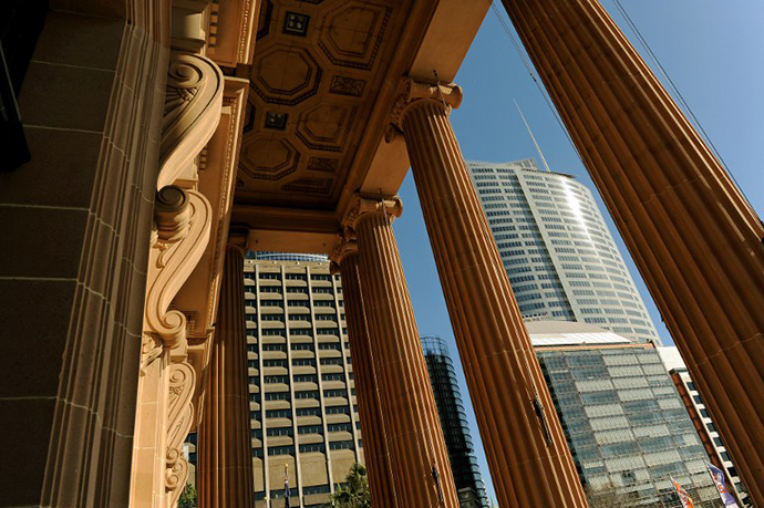 The front entrance to the Mitchell Wing of the State Library of New South Wales (NSW) frames modern office buildings in central Sydney (AFP Photo / Greg Wood)