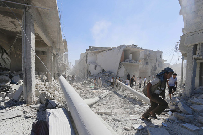 Residents inspect damage at a site hit by what activists said were barrel bombs dropped by forces of Syria's President Bashar al-Assad in the Ard Hamra district of Aleppo, September 20, 2014. (Reuters/Hosam Katan)
