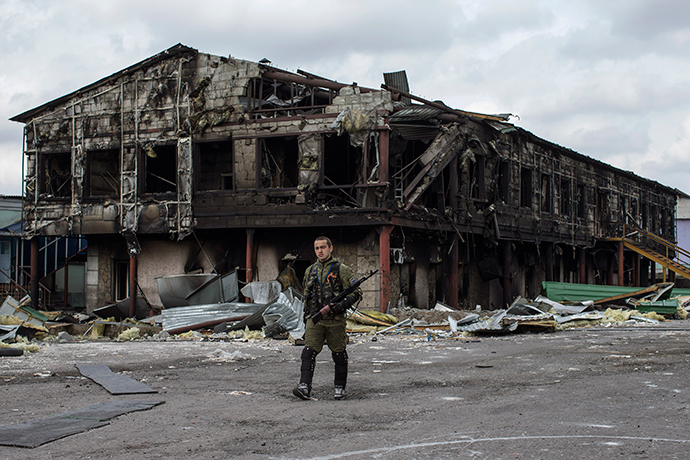 A rebel walks in front of a factory destroyed during recent shelling, in the town of Nizhnaya Krinka, eastern Ukraine, September 23, 2014 (Reuters / Marko Djurica)