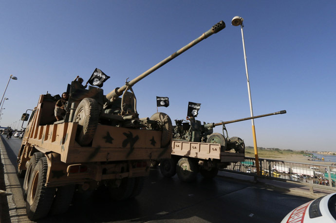 Militant Islamist fighters travel in a vehicle as they take part in a military parade along the streets of Syria's northern Raqqa province June 30, 2014. (Reuters/Striker)