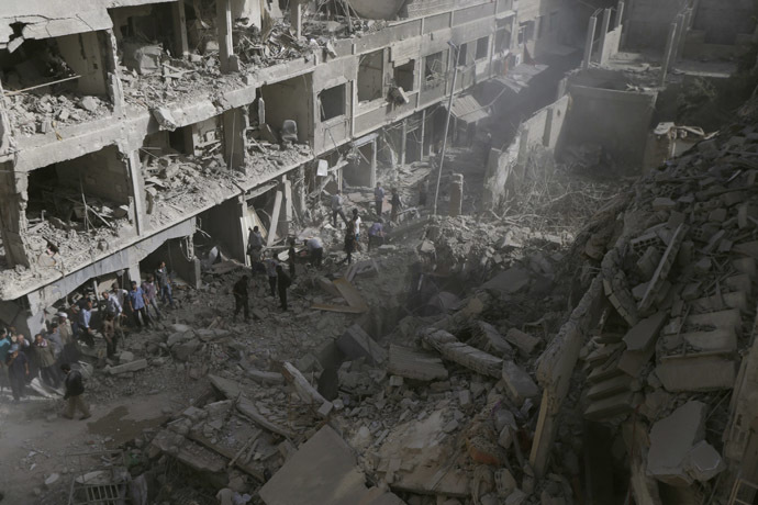 Residents inspect a damaged site after what activists say were four air strikes by forces loyal to Syria's President Bashar al-Assad in Douma, eastern al-Ghouta, near Damascus September 24, 2014. (Reuters/Bassam Khabieh)