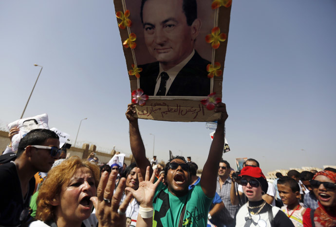 A supporter of former Egyptian President Hosni Mubarak holds his picture as he shouts slogans outside a police academy on the outskirts of Cairo September 27, 2014. (Reuters)