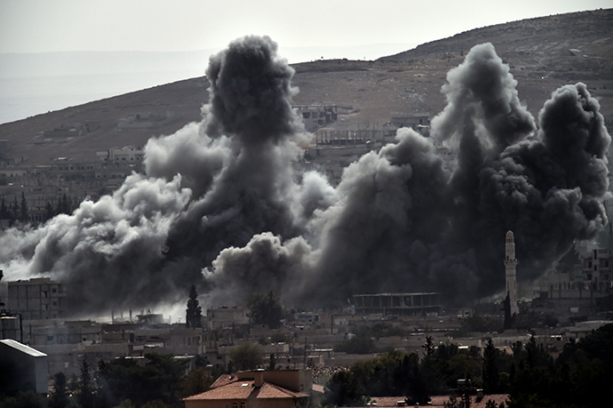 Smoke from a strike by the US-led coalition rises in the Syrian town of Ain al-Arab, known as Kobane by the Kurds, as it seen from the Turkish - Syrian border in the southeastern village of Mursitpinar, Sanliurfa province, on October 13, 2014. (AFP Photo / Aris Messinis)