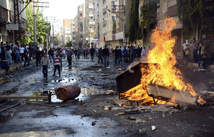 Kurdish protesters set fire to a barricade set up to block the street as they clash with riot police in Diyarbakir October 7, 2014. (Reuters/Stringer)