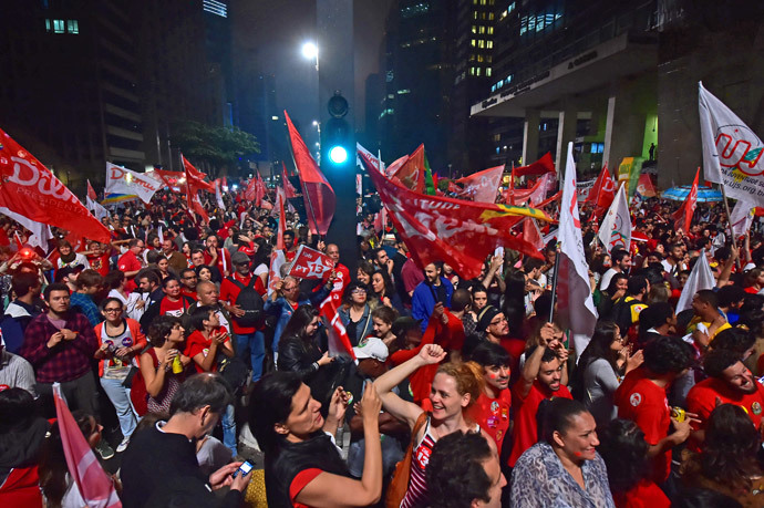 Supporters celebrate the reelection of the Brazilian President and presidential candidate for the Workers' Party (PT) Dilma Rousseff in the presidential election run-off along Paulista Avenue in Sao Paulo Brazil on October 26 2014. (AFP Photo / Nelson Almeida)