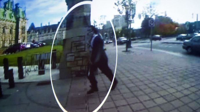 This image from a close circuit video shown during an October 23, 2014, press conference at Royal Canadian Mounted Police headquarters in Ottawa shows supected shooter Michael Zehaf-Bibeau (circled) running towards the Canadian Parliament. (AFP Photo / Peter Mccabe)