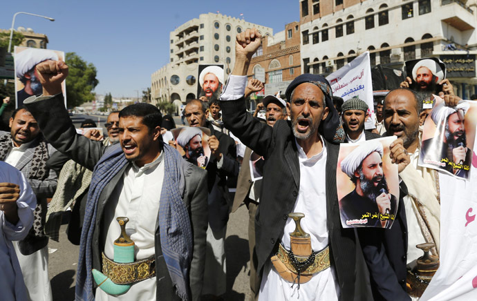 Shi'ite protesters shout slogans as they hold posters of Sheikh Nimr al-Nimr during a demonstration outside the Saudi embassy in Sanaa October 18, 2014. (Reuters/Khaled Abdullah)