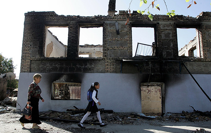 Ossetian people pass by a ruined house in Tskinvali. (AFP Photo/Kazbek Basayev)