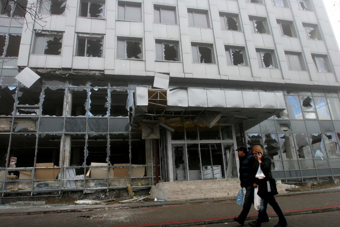 Donetsk residents walk past a building damaged during recent shelling by UKrainian forces. (RIA Novosti/Igor Maslov)