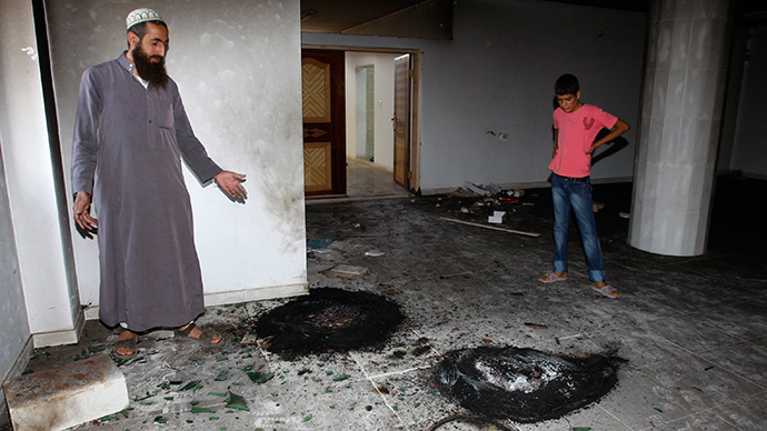 ARCHIVE PHOTO: Palestinians look at burnt tires inside a mosque in the West Bank village of Qusra, near Nablus September 5, 2011 (Reuters / Abed Omar Qusini)