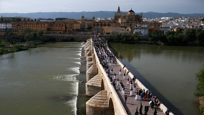 Penitents walk during a procession of the "La Vera-Cruz" brotherhood during Holy Week, on the Roman Bridge near the Mosque of Cordoba, southern Spain, April 14, 2014.(Reuters / Javier Barbancho)