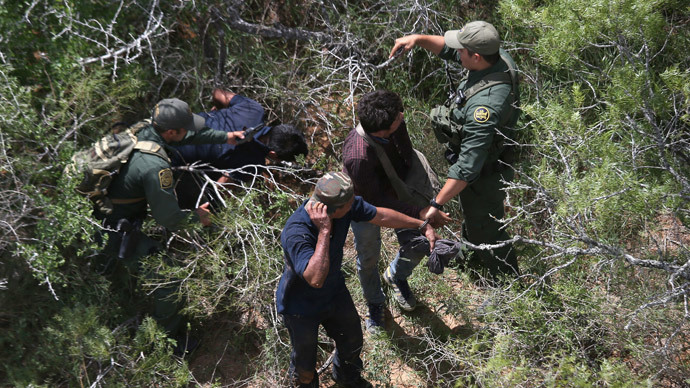 U.S. Border Patrol agents detain undocumented immigrants in the brush on September 11, 2014 near Falfurrias, Texas.(AFP Photo / John Moore)