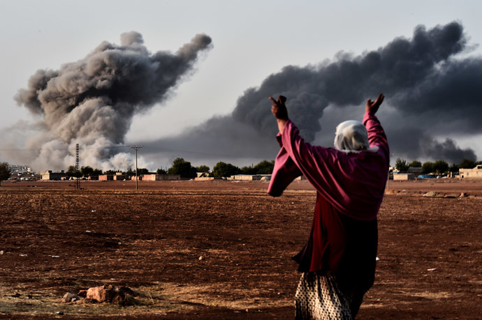 A woman reacts as smoke rises from the the Syrian town of Ain al-Arab, known as Kobane by the Kurds, after a strike from the US-led coalition as it seen from the Turkish - Syrian border in the southeastern village of Mursitpinar, Sanliurfa province, on October 13, 2014. (AFP Photo/Aris Messinis)