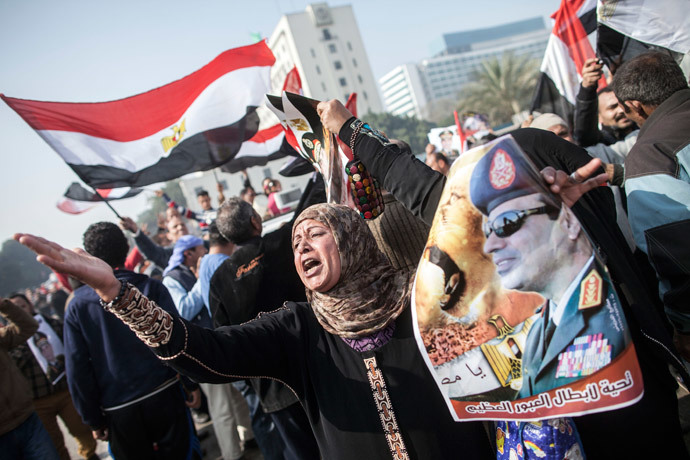 An Egyptian supporter of the military-installed government holds a poster bearing a portrait of General Abdel Fattah al-Sisi as she takes part in a rally marking the anniversary of the 2011 Arab Spring uprising in downtown Cairo on January 25, 2014. (AFP Photo / Mahmoud Khaled)