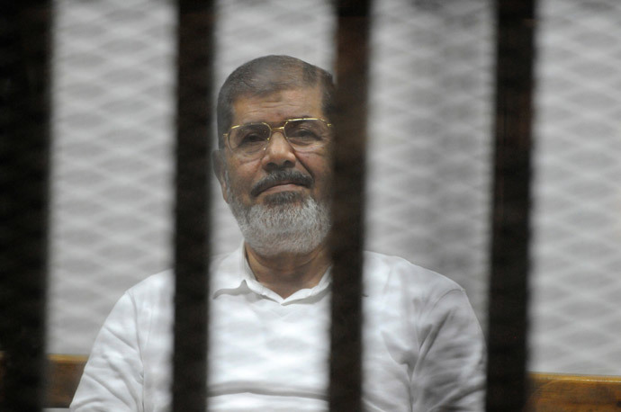 Egypt's deposed Islamist president Mohamed Morsi sists behind the defendants cage during a trial at the police academy court in Cairo on November 5, 2014. (AFP Photo / Str)
