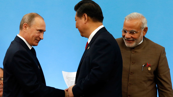 Russia's President Vladimir Putin (L) shakes hands with China's President Xi Jinping as India's Prime Minister Narendra Modi (R) looks on during the VI BRICS Summit in Fortaleza July 15, 2014.(Reuters / Paulo Whitaker)