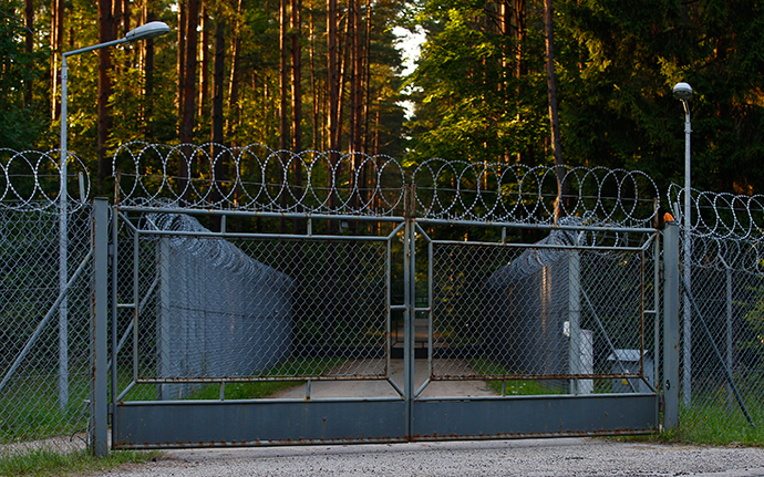 A car drives past barbed wire fence surrounding a military area in the forest in Stare Kiejkuty village, close to Szczytno in northeastern Poland (Reuters / Kacper Pempel)