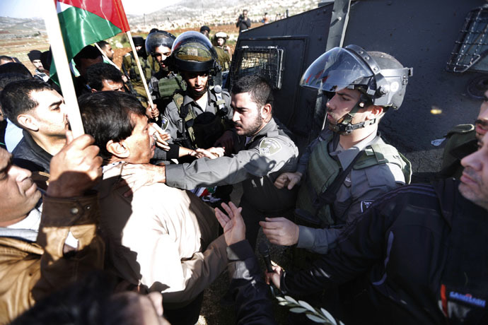 An Israeli border guard grabs Palestinian official Ziad Abu Ein (L), in charge of the issue of Israeli settlements for the Palestinian Authority, during a demonstration in the village of Turmus Aya near Ramallah, on December 10, 2014. (AFP Photo)