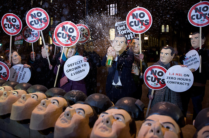 Anti-austerity protesters wearing masks of British Chancellor George Osborne, hold placards and chant slogans outside 10 Downing Street in central London on December 2, 2014, on the eve of the autumn statement (AFP Photo / Justin Tallis)