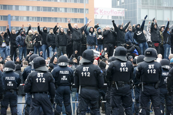 German riot police officers face protesters during a demonstration by neo-Nazis and self-styled soccer hooligans against ultra-conservative Islamic Salafists in Hanover November 15, 2014. (Reuters/Fabrizio Bensch)