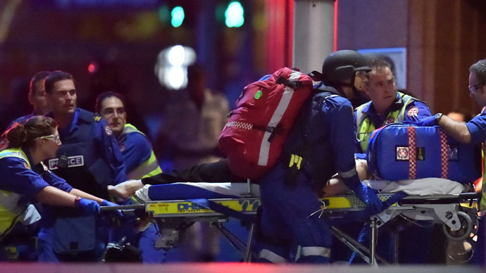 Australian paramedics work on an injured hostage as hostages are carried out of a cafe in the central business district of Sydney on December 16, 2014. (AFP Photo)
