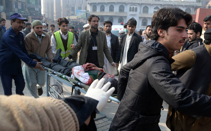 Pakistani men carry an injured student to a hospital following an attack by Taliban gunmen on a school in Peshawar on December 16, 2014. (AFP Photo)