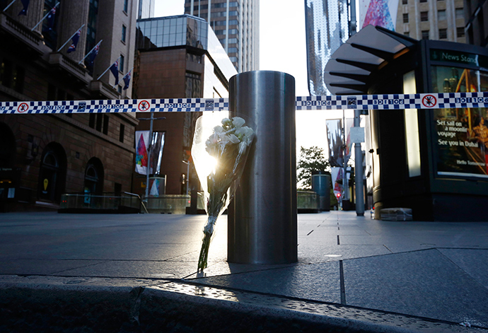 A bouquet is pictured under police tape near the cordoned-off scene of a hostage taking at Martin Place after it ended early December 16, 2014 (Reuters / Jason Reed)