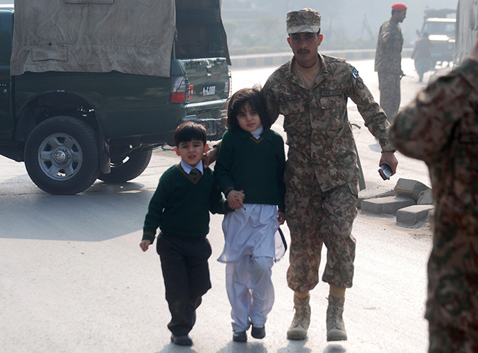 A soldier escorts schoolchildren from the Army Public School that is under attack by Taliban gunmen in Peshawar, December 16, 2014 (Reuters / Khuram Parvez)