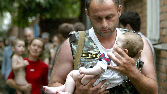 A Russian police officer carries a released baby from the school seized by heavily armed masked men and women in the town of Beslan in the province of North Ossetia near Chechnya, September 2, 2004.(Reuters / Viktor Korotayev)