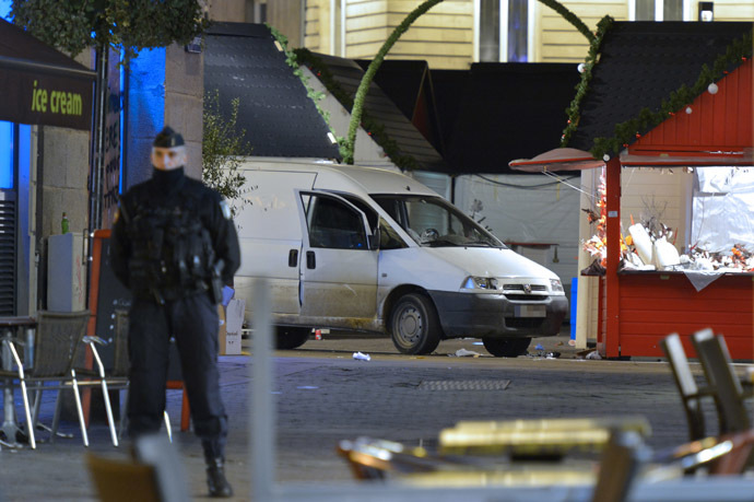 Police stand on the site where a the driver of a van (seen in picture) ploughed into a Christmas market injuring at least ten people before stabbing himself in the western French city of Nantes on December 22, 2014. (AFP Photo/Georges Gobet)
