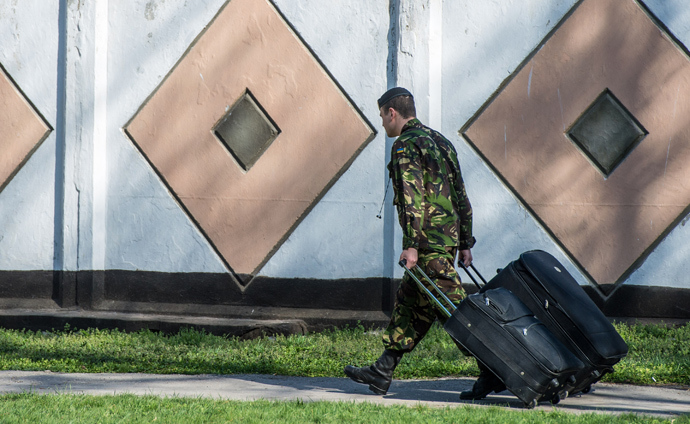 A Ukrainian marine carries their belongings as he leaves his military unit, Ukraine's only marine battalion, in the eastern Crimea's port city of Feodosiya (AFP Photo)