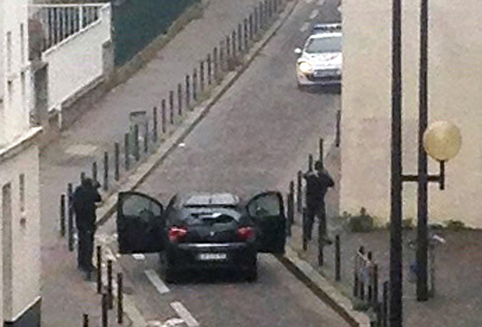 Armed gunmen face police officers near the offices of the French satirical newspaper Charlie Hebdo in Paris on January 7, 2015, during an attack on the offices of the newspaper which left at least 12 dead (AFP Photo / Anne Gelbard)