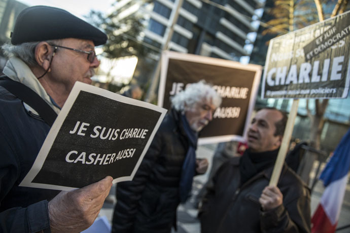 French-Israeli dual nationals hold signs reading in French "I am Charlie" during a remembrance ceremony in Tel Aviv on January 11, 2015, to protest against the attack on the French satirical magazine Charlie Hebdo's office that left 12 dead and an attack on a kosher supermarket in Paris. (AFP Photo)