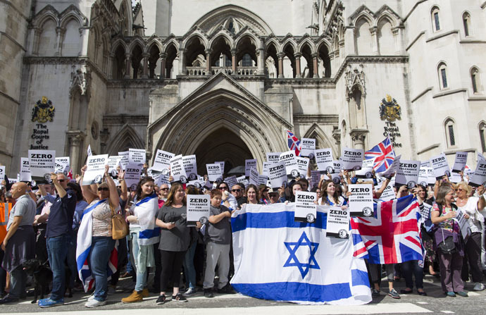 People hold placards and Israeli and Union flags outide the Royal Courts of Justice as Jewish groups rally in London on August 31, 2014, calling for "Zero Tolerance for Anti-Semitism". (AFP Photo/Justin Tallis)