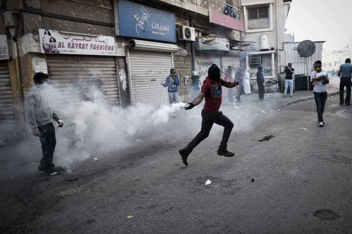 A Bahraini protestor throws back a tear gas canister during clashes with riot police following a protest on January 3, 2015 against the arrest of Sheikh Ali Salman, head of the Shiite opposition movement Al-Wefaq, in Salman's home village of Bilad al-Qadeem, on the outskirts of the capital Manama. (AFP Photo/Mohammed Al-Shaikh)