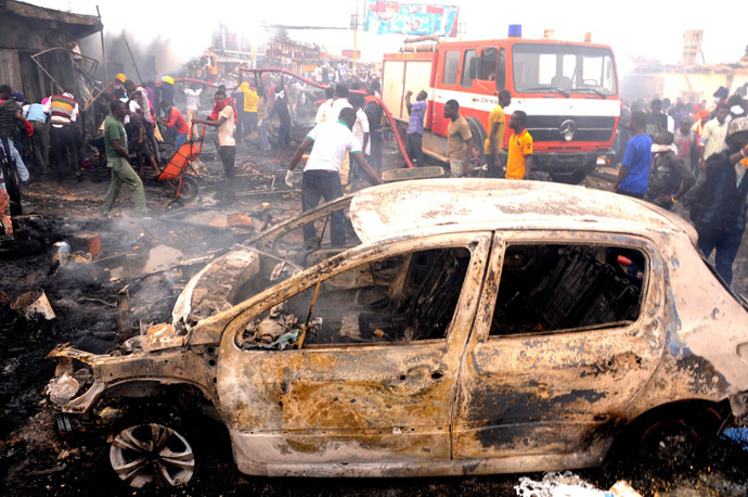 Firefighters and rescuers extinguish a fire at the scene of a bomb blast at Terminus market in the central city of Jos on May 20, 2014. (AFP Photo/Str)