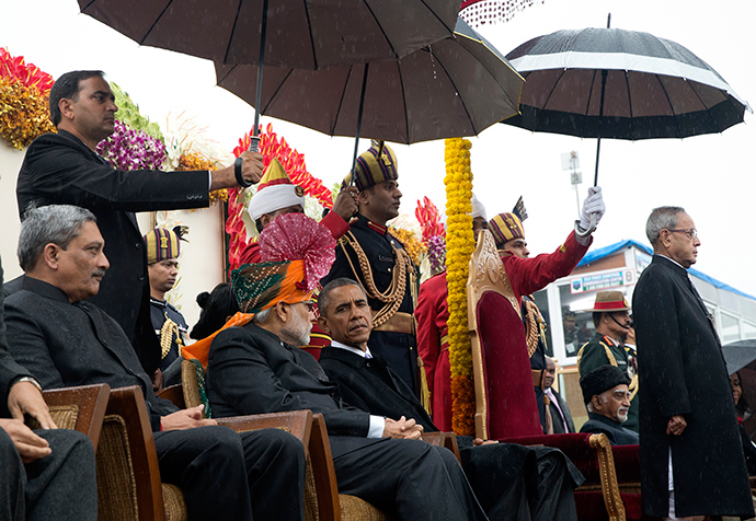 India's Prime Minister Narendra Modi (centre L) and U.S. President Barack Obama (centre R) sit under umbrellas watching India's Republic Day parade in the rain together from their review stand in New Delhi January 26, 2015 (Reuters / Stephen Crowley)