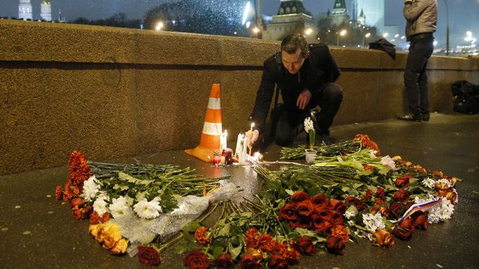 A man places a lit candle at the place where Boris Nemtsov was shot dead near the Kremlin in central Moscow February 28, 2015. (Reuters/Maxim Shemetov)