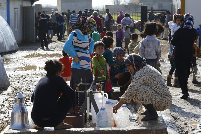 Kurdish refugees from the Syrian town of Kobani wait to fill their jerrycans around a clean water source at a refugee camp in the border town of Suruc, Sanliurfa province February 1, 2015. (Reuters/Umit Bekta)