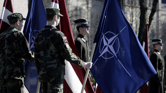 Latvia's army soldiers hold NATO (R) and Latvian flags during a celebration of the anniversary of Latvia joining the NATO, in Riga. (Reuters/Ints Kalnins)