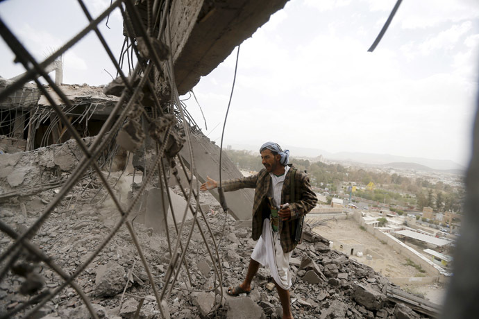 A man reacts as he inspects the damage of a building caused by an air strike in Sanaa April 8, 2015. (Reuters/Khaled Abdullah)