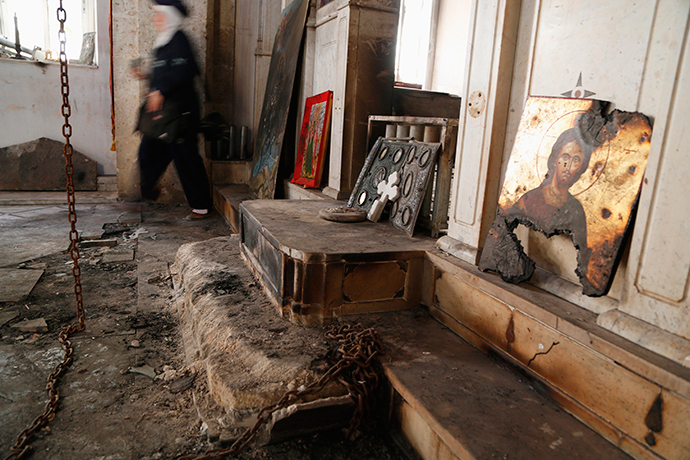 A woman walks inside a damaged church in Maaloula August 21, 2014. Residents of Maaloula, a Christian town in Syria, call on other Christian groups and minorities to stand up to the radicalism that is sweeping across Syria and Iraq (Reuters / Omar Sanadiki)