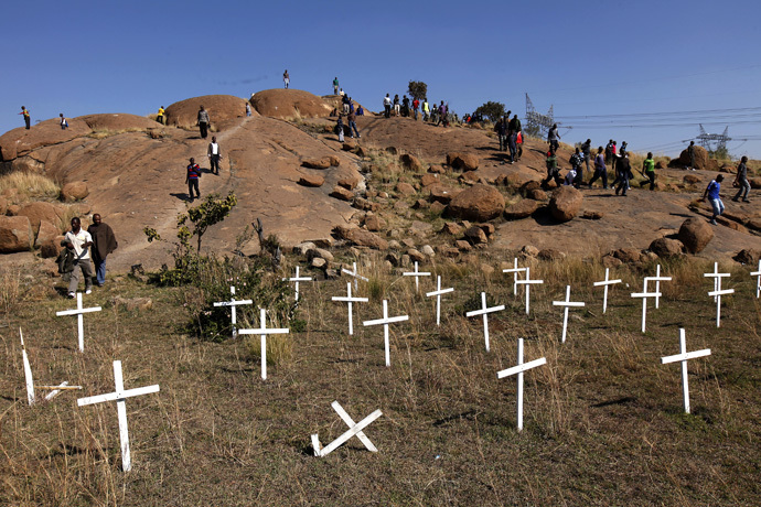 Members of the mining community walk near crosses placed at a hill known as the "Hill of Horror", where 43 miners died during clashes with police last year, during a strike at Lonmin's Marikana platinum mine in Rustenburg, 100 km (62 miles) northwest of Johannesburg, May 14, 2013. (Reuters/Siphiwe Sibeko)