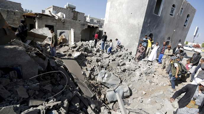 People stand on the rubble of houses destroyed by an air strike near Sanaa Airport (Reuters / Khaled Abdullah)