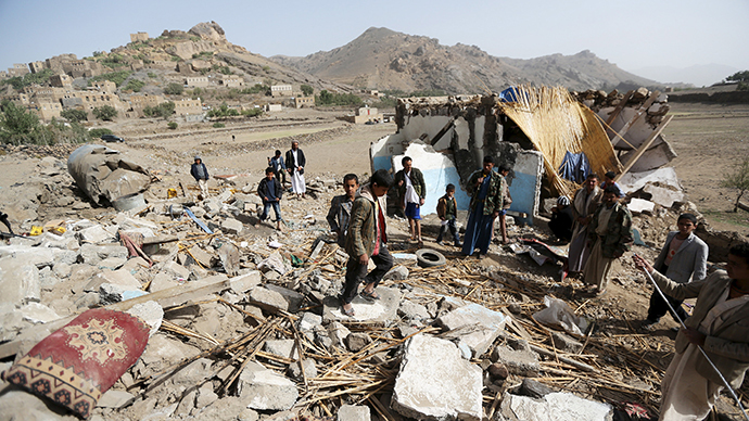 People gather around the wreckage of a house destroyed by an air strike in the Bait Rejal village, west of Yemen's capital Sanaa (Reuters / Khaled Abdullah)