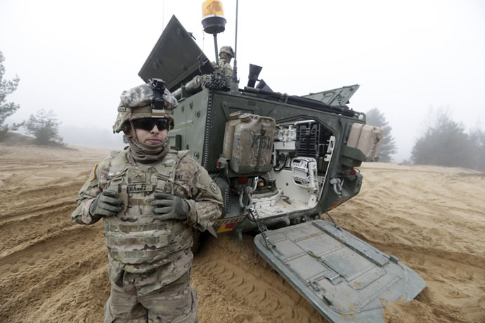 Soldiers of the U.S. Army's 2nd Cavalry Regiment, deployed in Latvia as part of NATO's Operation Atlantic Resolve, are pictured near their armored vehicle named "Stryker" during a joint military exercise in Adazi February 26, 2015. (Reuters/Ints Kalnins)