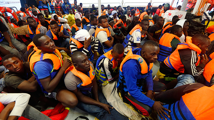 Migrants sit on the deck of the NGO Migrant Offshore Aid Station (MOAS) ship Phoenix after arriving at the port of Pozzallo in Sicily in this handout photo provided by MOAS (Reuters / Darrin Zammit Lupi)